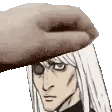 a hand is holding a man 's head with a hat on it .