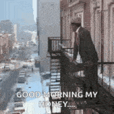 a man in a suit and tie is standing on a fire escape in front of a building .