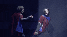 a man and a woman are standing next to each other on a stage and one of them is sticking out her tongue
