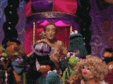 a group of sesame street puppets are standing around a man