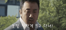 a close up of a man 's face with korean writing on the bottom