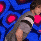 a man wearing headphones is dancing in front of a blue background
