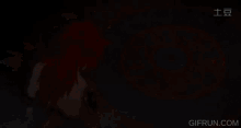 a gif from gifrun.com shows a person with red hair standing in front of a circular pattern