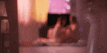 a blurry picture of a person laying on a bed using a laptop .