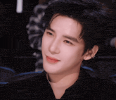 a close up of a person 's face with a black jacket