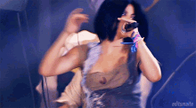 a woman singing into a microphone with editsmaite in the corner