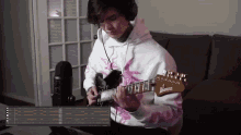 a man wearing headphones is playing an ibanez electric guitar