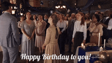 a group of people standing around a table with the words happy birthday to you on it