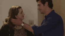 a man and woman are hugging each other in a room .