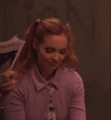 a woman in a purple shirt and tie is holding a newspaper that says " united states "
