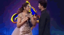 a man and a woman are dancing on a stage in front of a sign that says ' spicy ' .