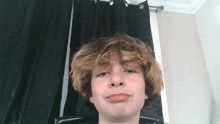 a young boy with blonde hair making a funny face