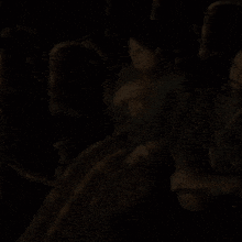 a man and woman are sitting in a dark room