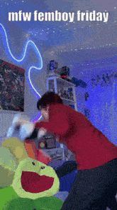 a person is fighting a stuffed frog in a room with the words mfw femboy friday written on the bottom