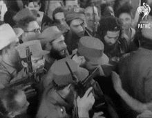 a black and white photo of a crowd of people with pathe written on the bottom left
