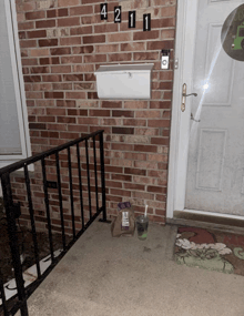 a brick wall with a mailbox and the number 421 on it