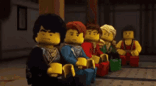 a group of lego minifigures are sitting in a row .