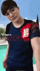 a man wearing glasses and a shirt that says viggle.ai is standing in front of a pool