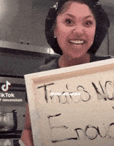 a woman is holding up a sign that says " this is no enough "