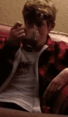 a man sitting on a couch drinking a glass of beer