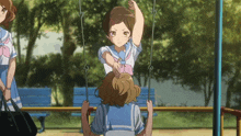 a girl in a blue and white uniform is playing on a swing
