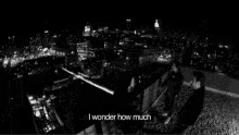 a man is standing in front of a city skyline at night .