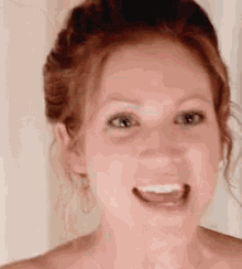 a woman with red hair is smiling and making a funny face .