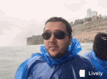 a man wearing sunglasses and a blue poncho with the word lively on the bottom right