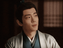 a man wearing a kimono and a blue vest looks to his right