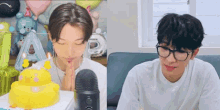 a couple of men are sitting next to each other in front of a microphone .