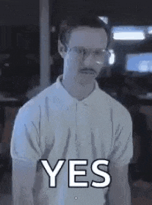 a man with glasses and a mustache is wearing a white shirt and saying yes .