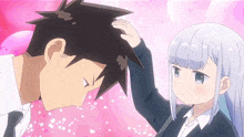 a girl touches a man 's head with her hand