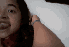 a close up of a girl 's face with a person holding her hair .