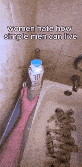 a person is holding a bottle of monster milk in a bathtub with empty bottles in it