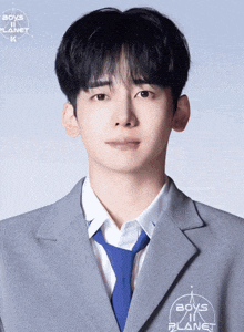 a young man is wearing a suit and tie with boys in planet written on his jacket