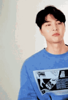 a young man is wearing a blue sweatshirt with a picture of a cell phone on it