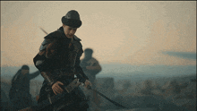 a man in armor holds a sword in front of a group of people
