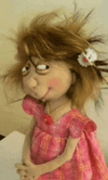 a doll in a pink dress with a flower in her hair .