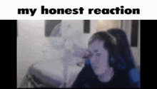 a woman wearing headphones is sitting in front of a fan with the words " my honest reaction " above her