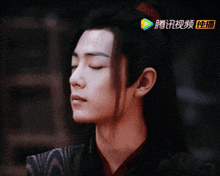 a close up of a man 's face with chinese writing on the bottom left