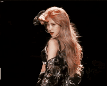 a woman with long blonde hair is wrapped in plastic wrap and dancing on a stage .