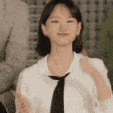 a woman wearing a white shirt and a black tie is smiling .