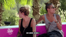 two women are sitting on a pink couch and one of them is saying oh mon diiieu