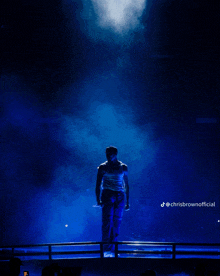 a man stands on a stage with chrisbrownofficial written in the corner