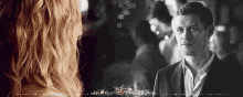 a man and a woman are looking at each other .