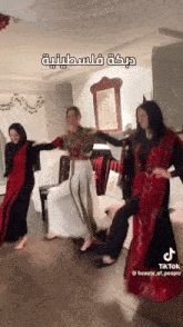 three women are dancing in a living room with arabic writing on the bottom