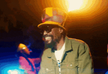 a man with a beard wearing a hat and sunglasses is smiling
