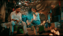 a man and a woman are sitting on a bench talking to each other