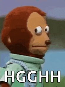 a stuffed monkey is making a funny face with the words hgghh written below it .