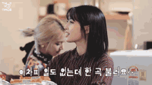 two girls are standing next to each other in a kitchen and one of them is wearing a striped shirt
